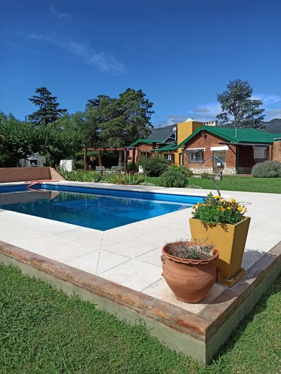 a swimming pool with two potted plants next to it at La Estrella 3 in Huerta Grande