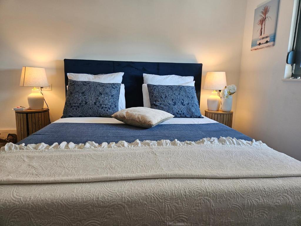 a bedroom with a large bed with blue sheets and pillows at Il Vento in Split