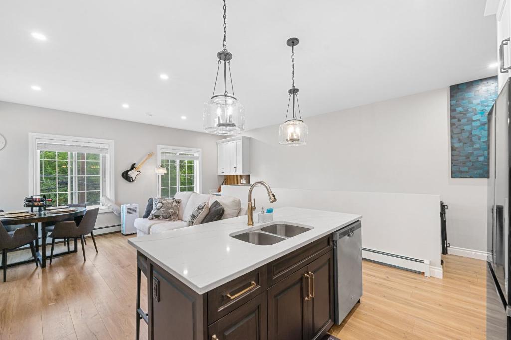 a kitchen with a sink and a living room at Casa Ladrillo - House of Bricks in Calgary