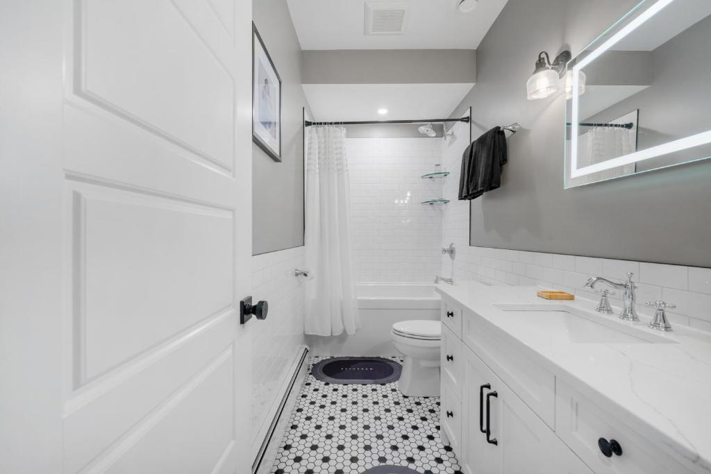 a white bathroom with a sink and a toilet at Casa Ladrillo - House of Bricks in Calgary