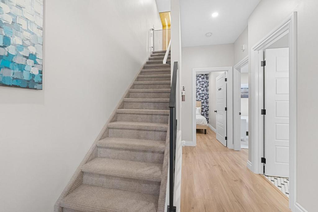 a staircase in a home with white walls and wood floors at Casa Ladrillo - House of Bricks in Calgary