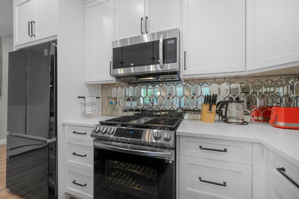 a kitchen with a black stove and a microwave at Casa Ladrillo - House of Bricks in Calgary