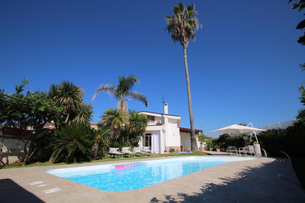 basen przed domem z palmami w obiekcie Edri beach house - Villa con piscina w mieście Pontecagnano