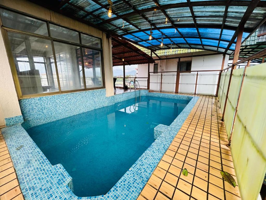 a large swimming pool in a building with blue tiles at PP with rooftop pool and bathtub in Lonavala