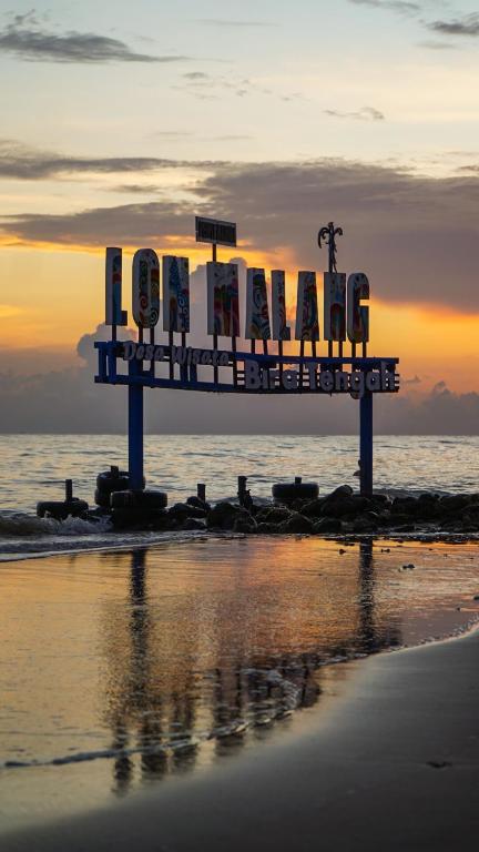 SokobanaCamping Ground beach的海滩上的标志,背景是日落