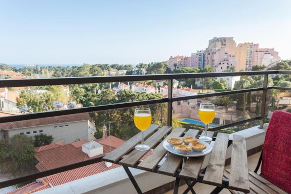 a table with two glasses of orange juice on a balcony at Cascais Panoramic Apartment in Cascais