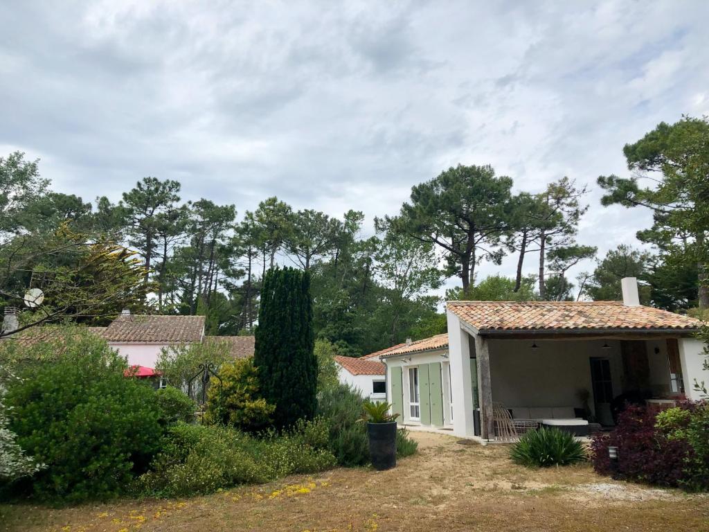 une petite maison blanche avec une véranda et des arbres dans l'établissement Filatte, aux Portes