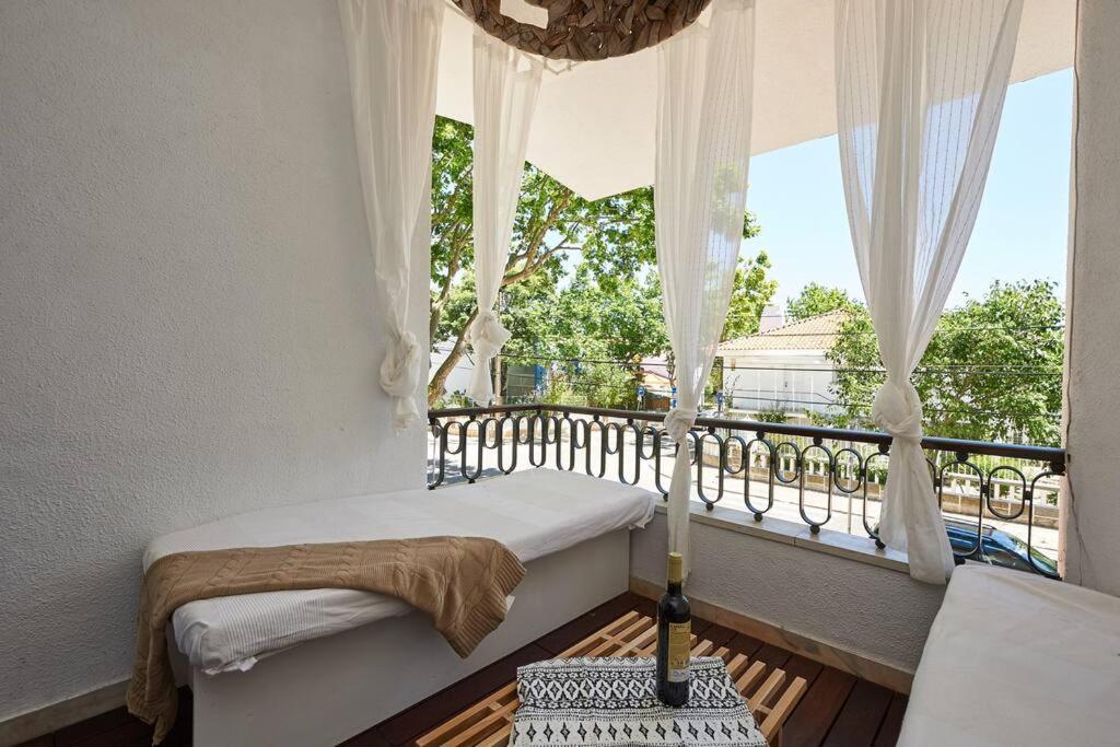 a bedroom with a balcony with a bed and a window at Central Oasis Apartment in Cascais