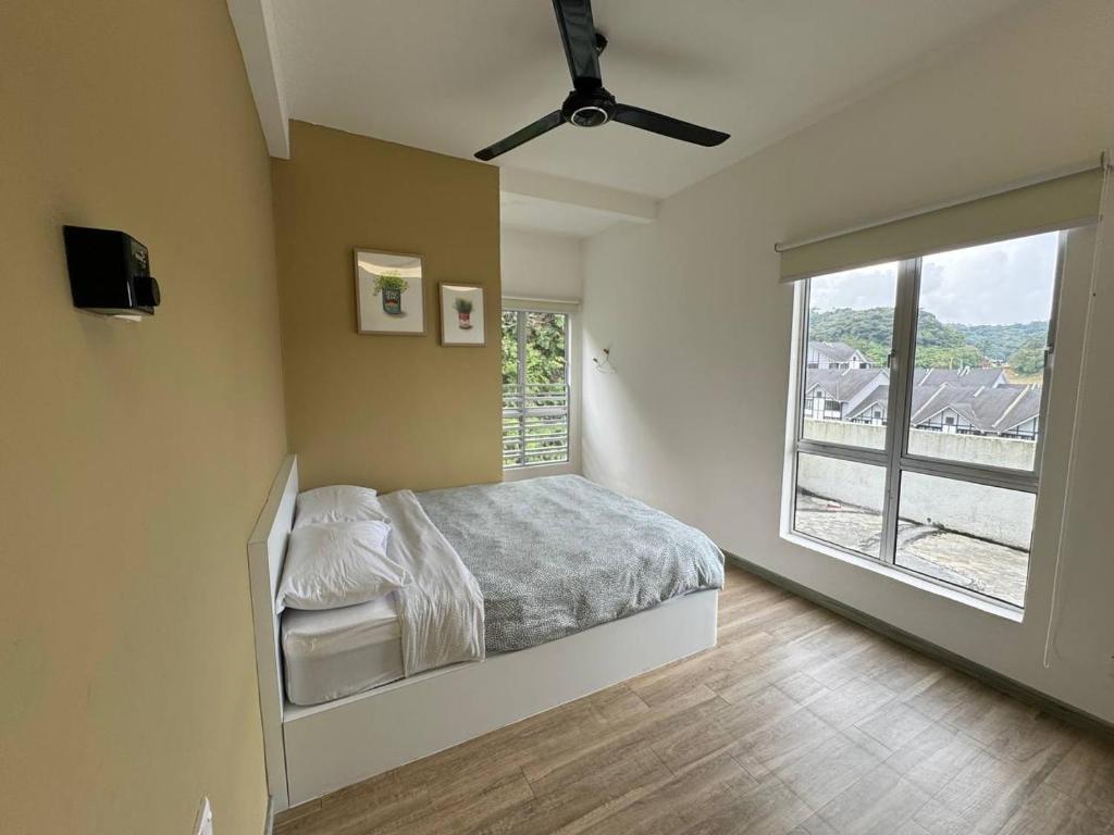 una camera da letto con un letto e una grande finestra di Eisya Homestay Emerald Avenue Brinchang a Brinchang