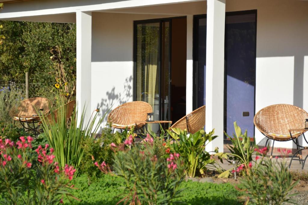 a patio with chairs and flowers in front of a house at La Maravilla Lodge in Vilches