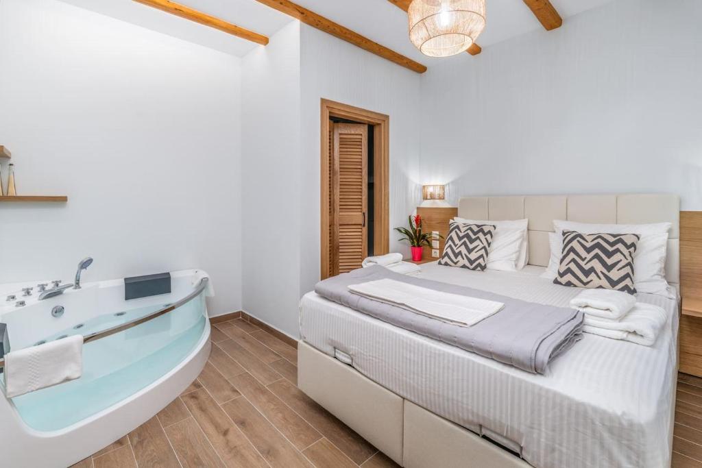 un dormitorio con una cama y una bañera en Coquelicot Appartement, en Lefkada