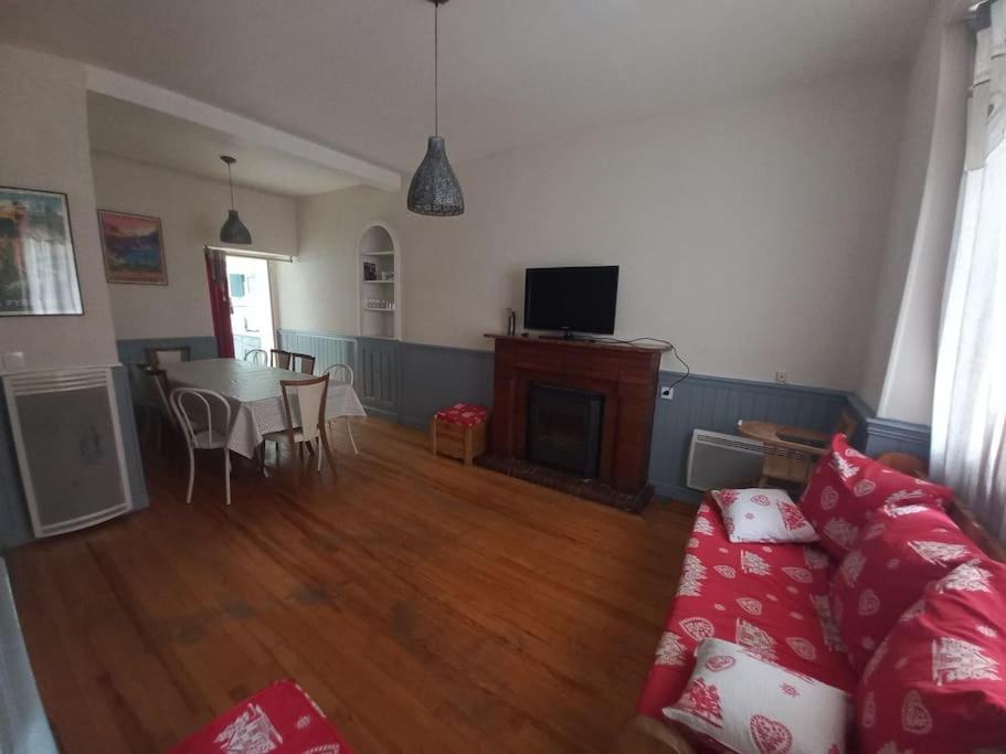 ein Wohnzimmer mit Sofa und Tisch in der Unterkunft Agréable maison de ville avec cheminée in Luchon