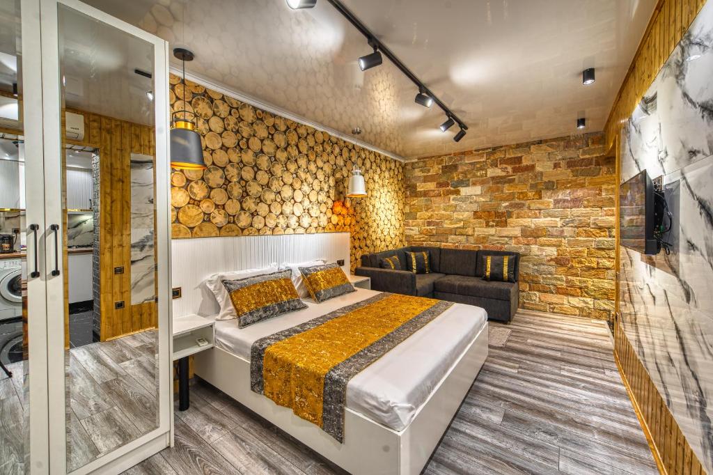 a bedroom with a bed and a couch in a room at Квартира на Арбате 1 ком in Shymkent