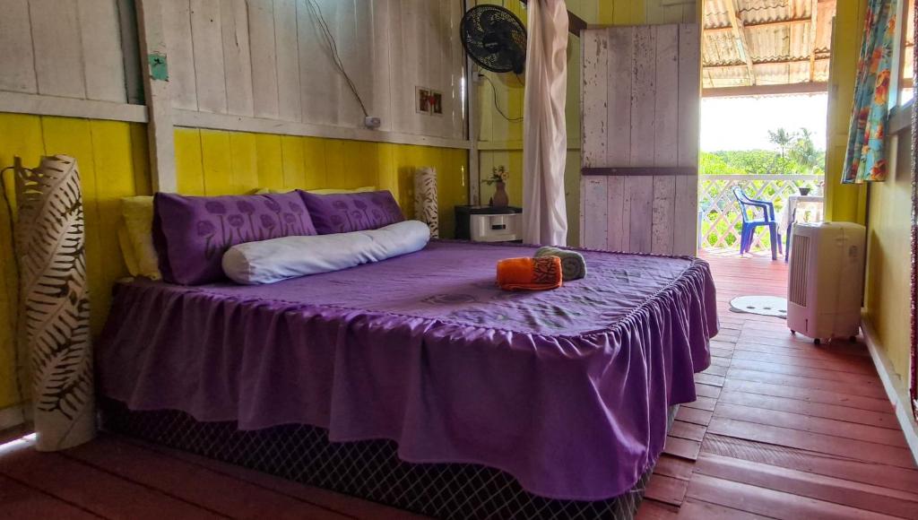Un dormitorio con una cama morada con una manta morada. en Redário Pôr Do Sol - Hospedagem e Experiência no Marajó, en Soure