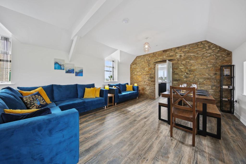 a living room with a blue couch and a table at Host & Stay - The Staffordshire Knot in Buxton