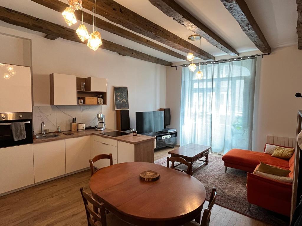 Il dispose d'une cuisine et d'un salon avec une table et un canapé. dans l'établissement Appartement Solidor 50m2 et jardin à deux pas des plages, à Saint-Malo
