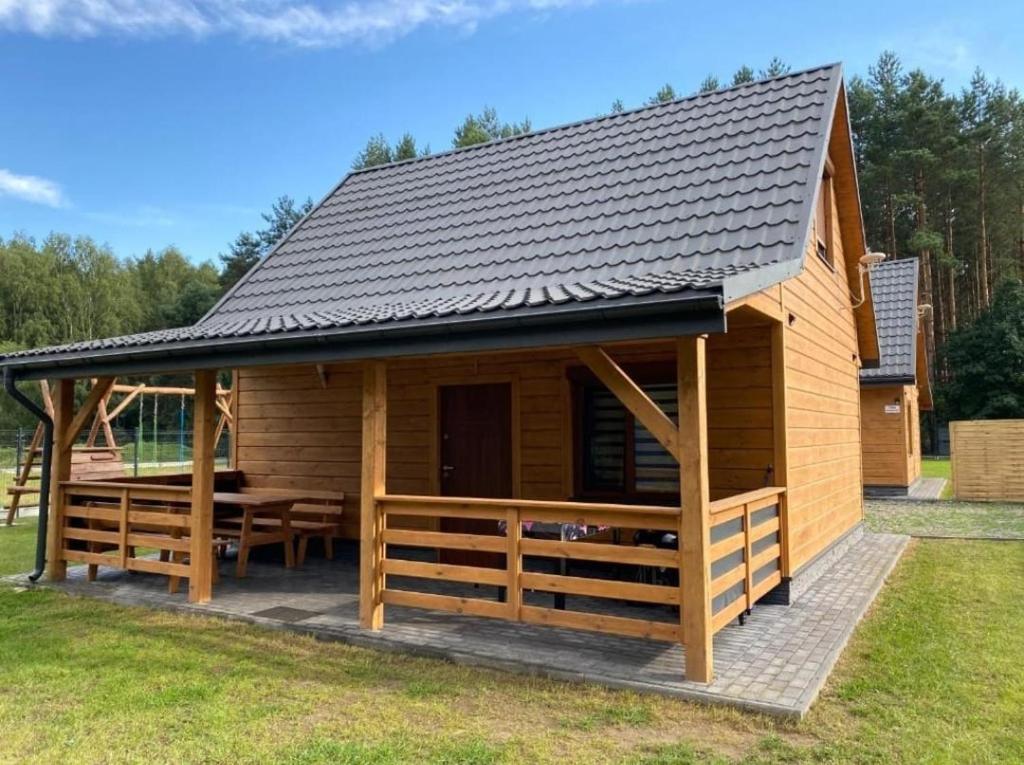 a large wooden cabin with a pitched roof at Domki za Lasem in Radawa