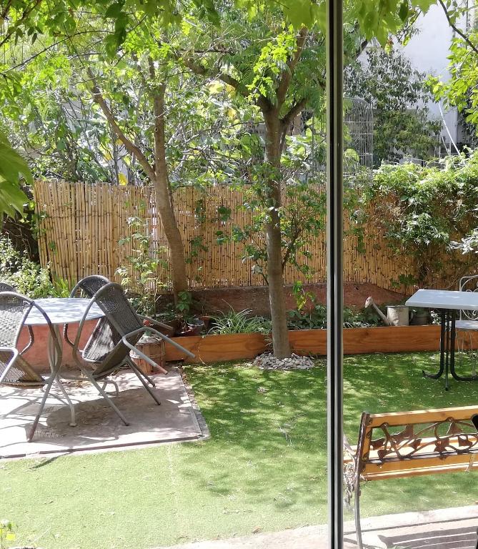 d'un jardin avec une table, des chaises et une clôture. dans l'établissement AU PALAIS DES ROIS de MAJORQUE, à Perpignan