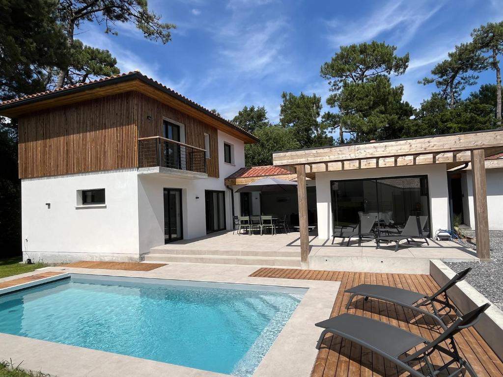 une maison avec une piscine et une terrasse dans l'établissement Villas-des-oyats - Ophila - 8 personnes climatisée piscine chauffée, à Seignosse