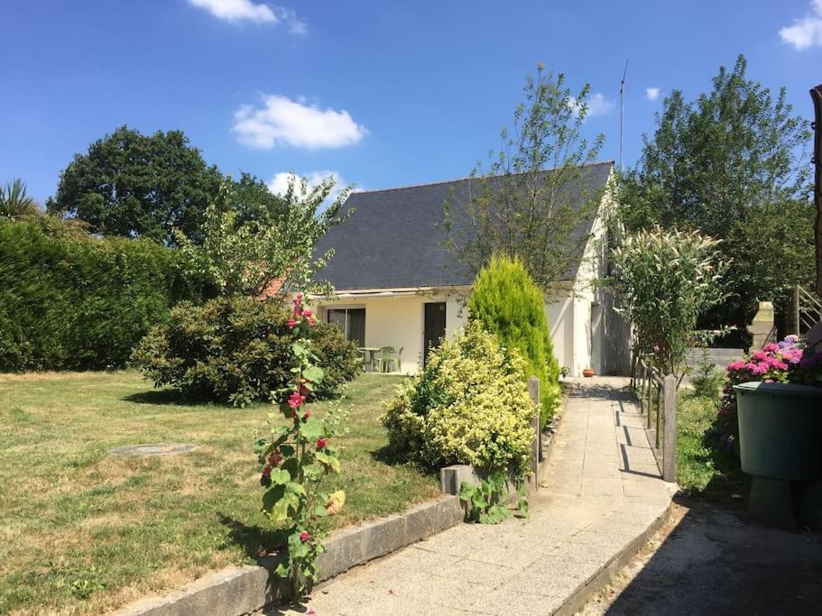 une maison avec une cour ornée de fleurs et de plantes dans l'établissement La Josettine Mont-Saint-Michel, à Champcey