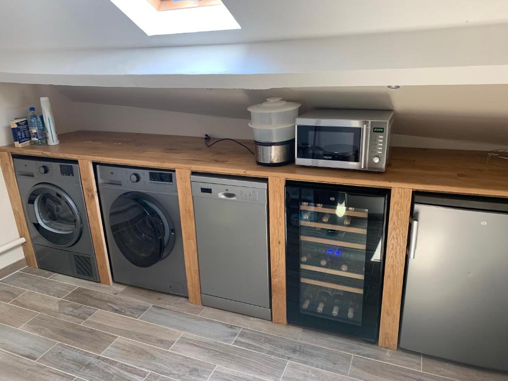 une cuisine avec un micro-ondes et un lave-linge et un sèche-linge dans l'établissement Maison de campagne, à Saint-Étienne-de-Vicq