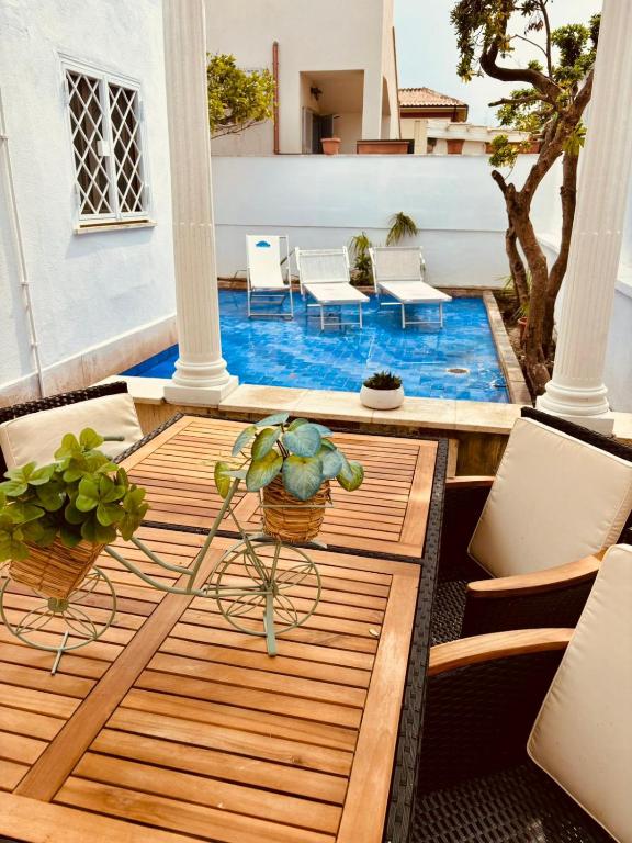 a patio with a table and chairs and a pool at Mare di Roma 2 in Lido di Ostia
