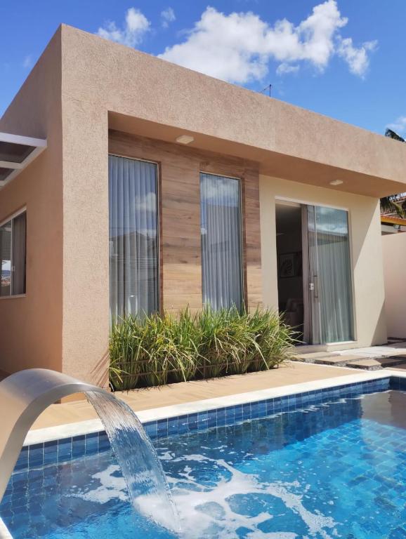 a villa with a swimming pool and a house at Casa Jacuípe in Camaçari