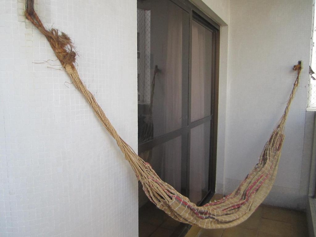 a hammock hanging on a wall next to a window at Apartamento Vista Mar - 2 Garagens in Guarujá