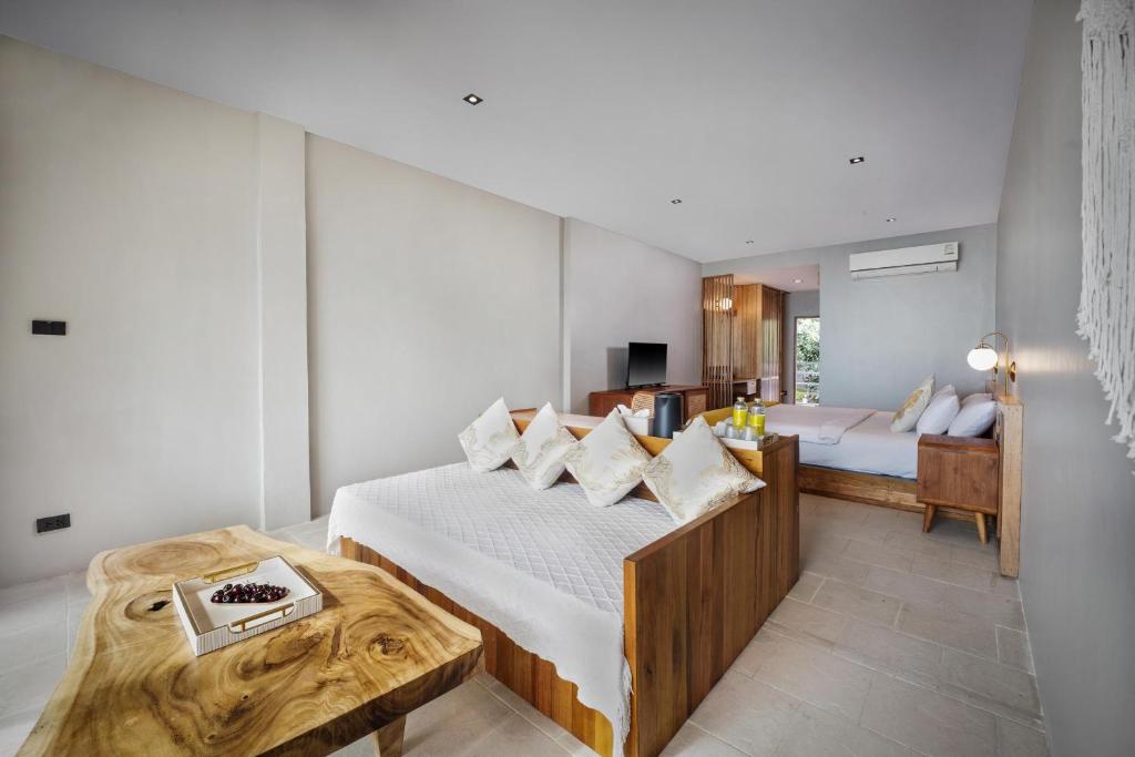 a bedroom with a bed and a desk in a room at Dusit Buncha Koh Tao by Riya Group in Ko Tao