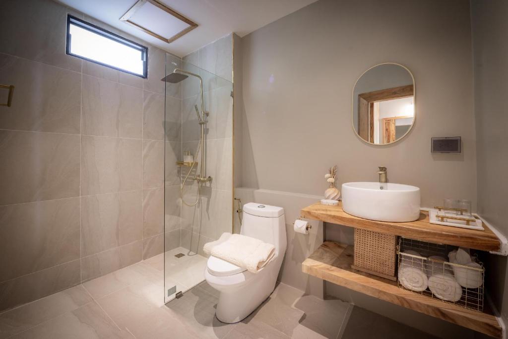 a bathroom with a toilet and a sink and a shower at Dusit Buncha Koh Tao by Riya Group in Ko Tao