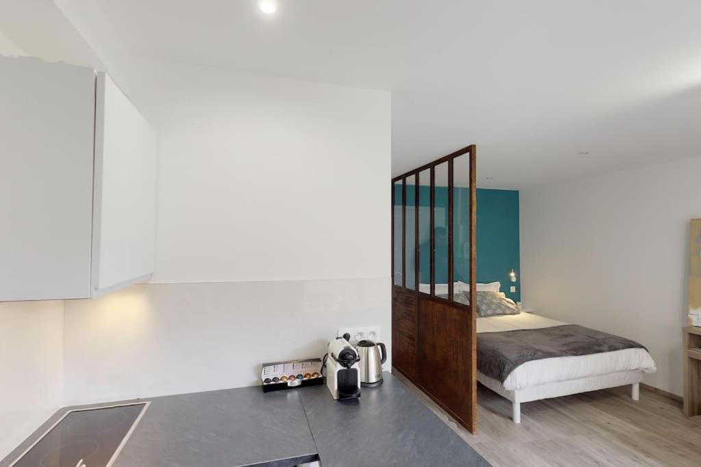 eine Küche mit Spiegel und ein Bett in einem Zimmer in der Unterkunft Appart 3 pers piscine parking coeur de ville in Grenoble