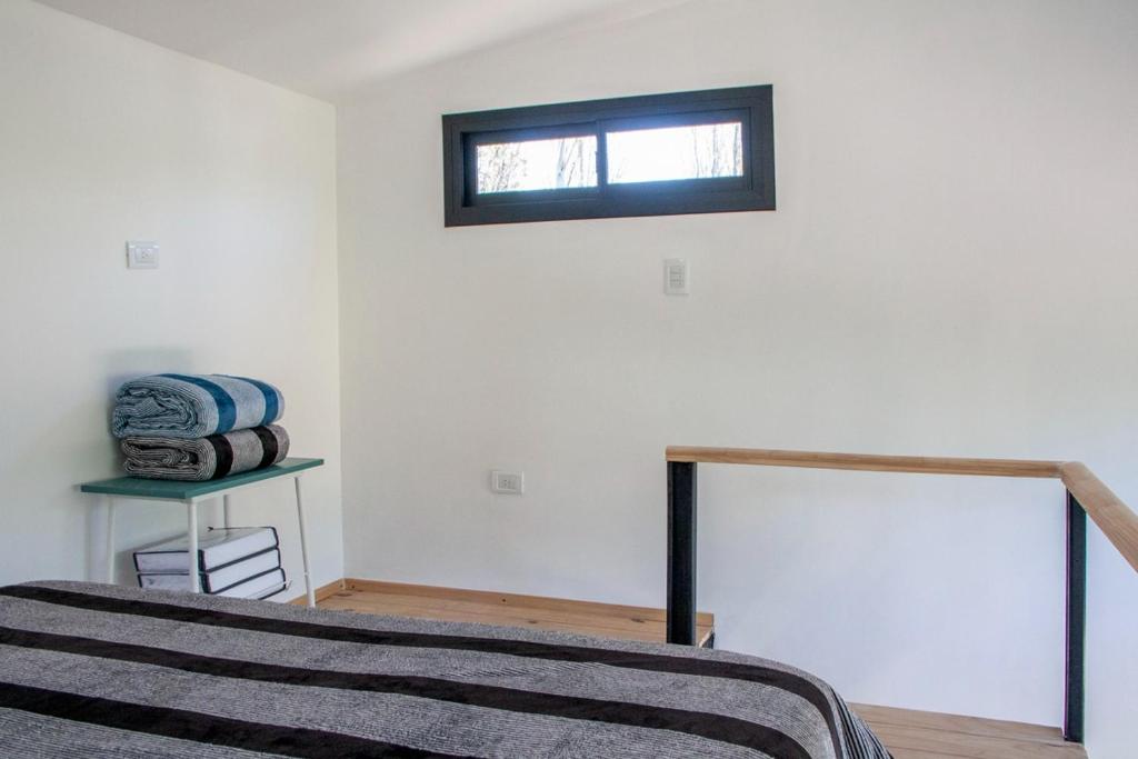 a bedroom with a bed and a window on the wall at Minicasas in Villa Ciudad Parque