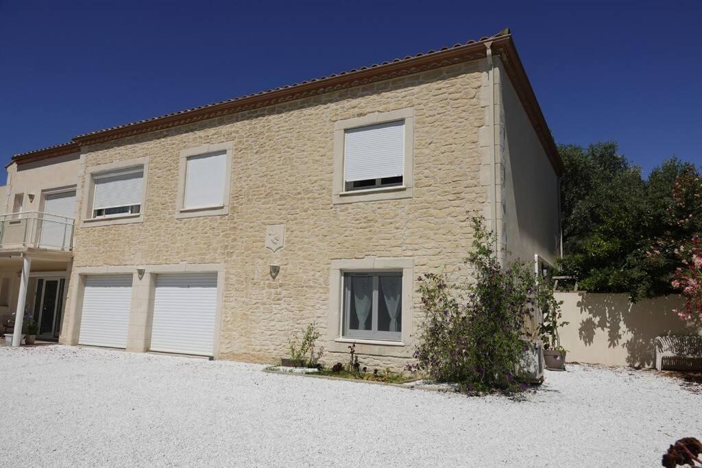 une grande maison en briques avec deux portes de garage dans l'établissement La Cigale - Climatisation - proche mer - Calme, à Villeveyrac
