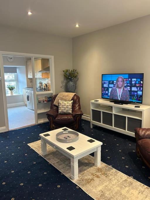 a living room with a tv and a couch and a table at No 12 Bridge Street - Town Centre Apartment in Westport