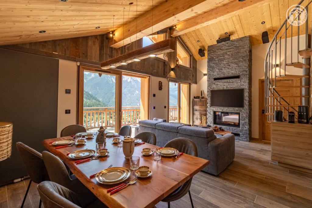 une salle à manger avec une table et un canapé dans l'établissement 200 m des télécabines, Cheminée & Cosy, à Champagny-en-Vanoise