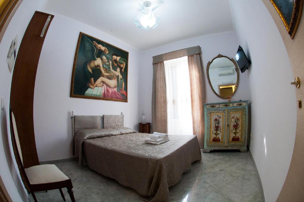 ローマにあるCasavamicaのベッドルーム1室(ベッド1台、鏡、テーブル付)
