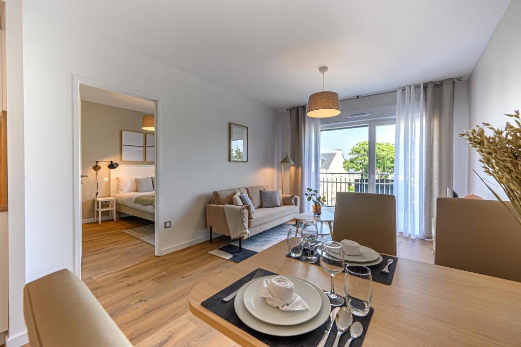 une salle à manger et un salon avec une table et des chaises dans l'établissement OVELIA Fouesnant - Les Allées de Kervihan, à Fouesnant
