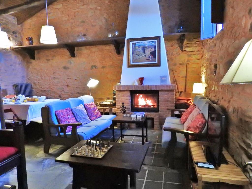 sala de estar con sofá azul y chimenea en La Casa De Murias, en Murias de Rechivaldo