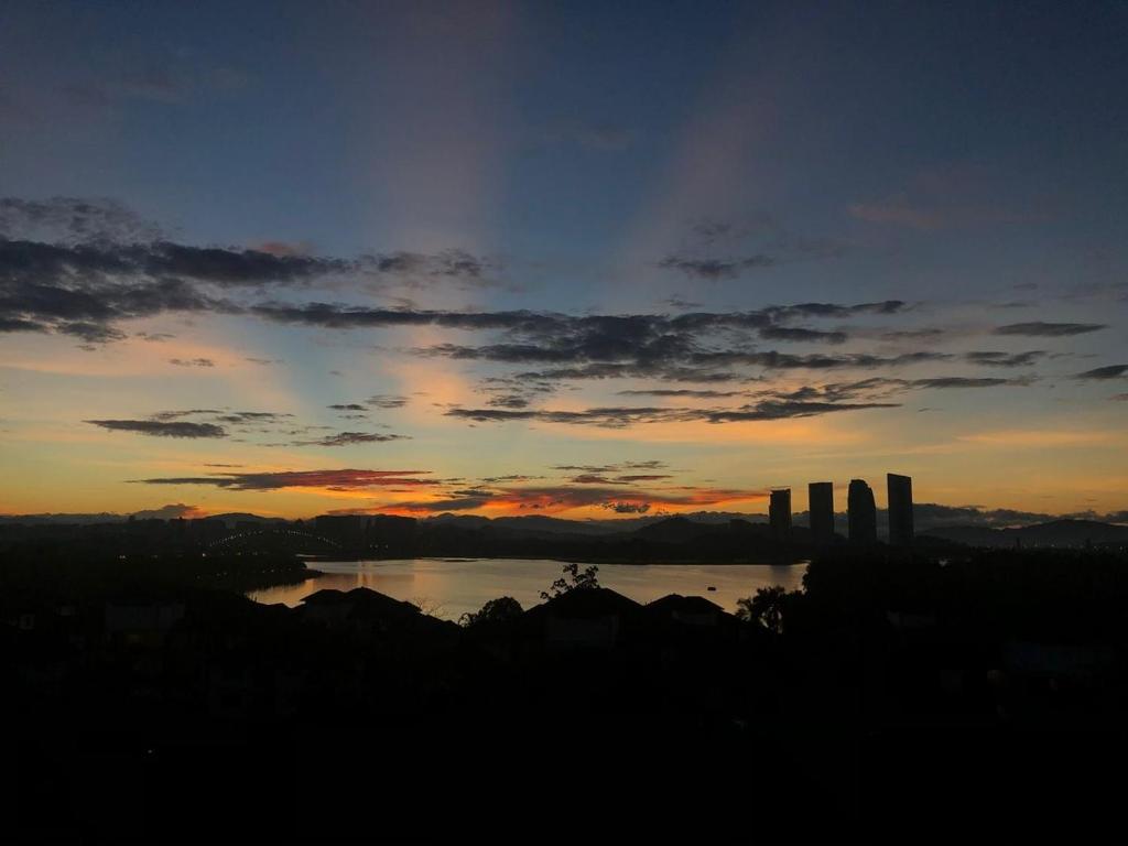 a sunset over a body of water with a city at Casa Blanca R2 in Cyberjaya
