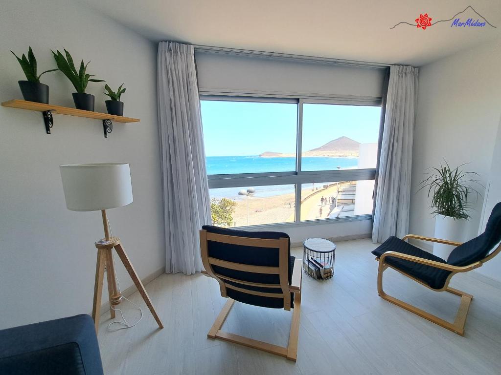 ein Wohnzimmer mit Blick auf das Meer in der Unterkunft MarMédano Apartamento 2 in El Médano