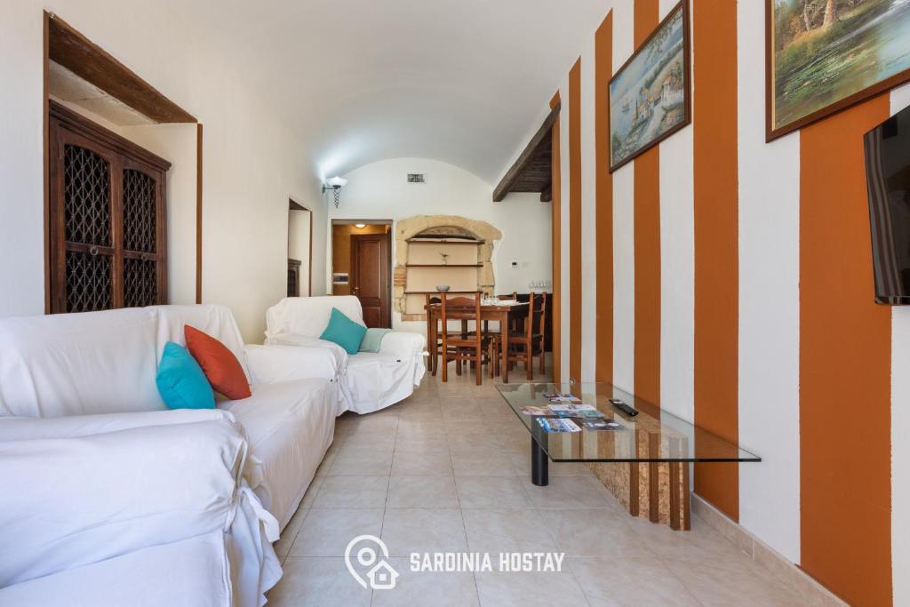 a living room with white couches and a glass table at Living Villanova Apartment in Cagliari