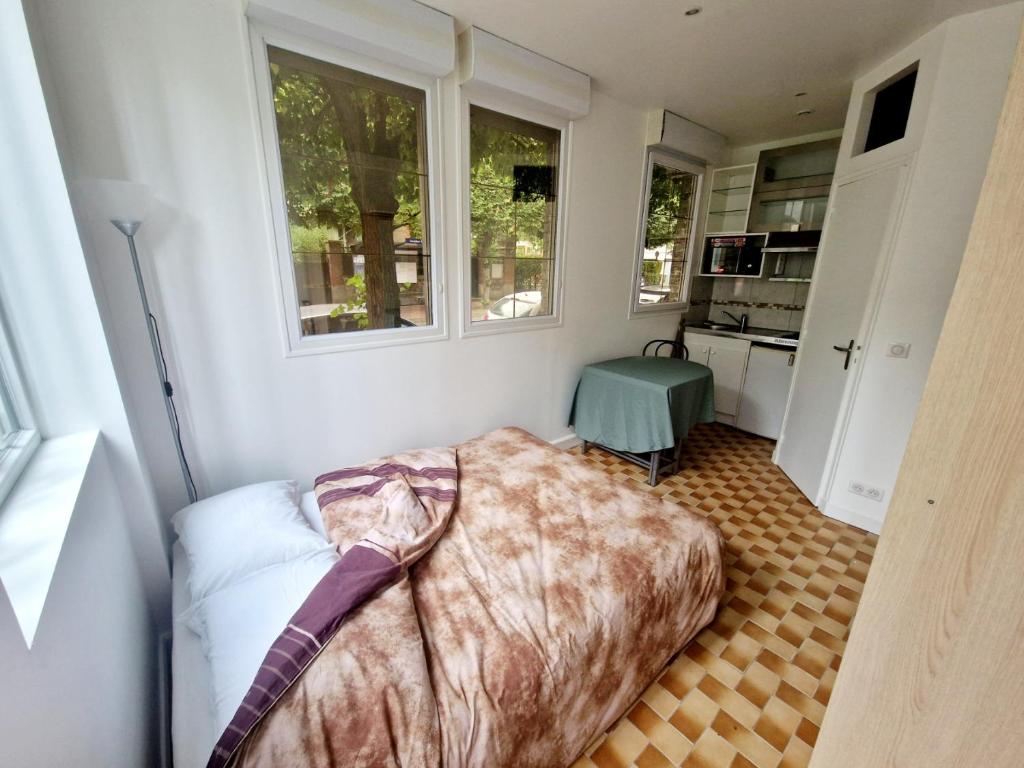 a bedroom with a bed in the corner of a room at Studio Porte de Versailles in Vanves