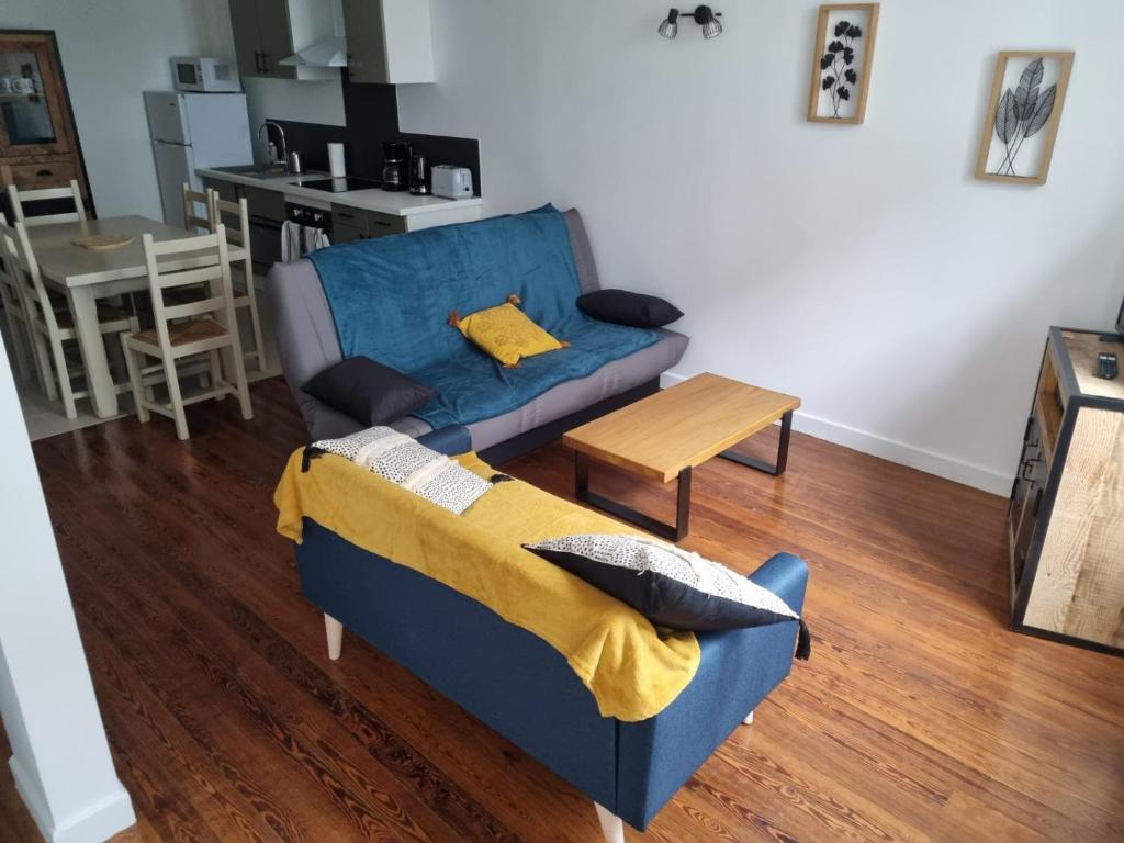 un salon avec un canapé bleu et une table dans l'établissement T3 Macon Centre Rambuteau, à Mâcon