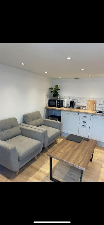 a living room with two couches and a table at UG Apartment in Bangor