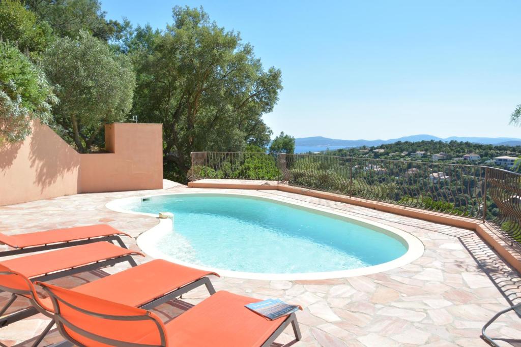 - une piscine avec 2 chaises et une piscine dans l'établissement Provenzalisches Haus La Grenouille - Terrasse mit Meerblick und privatem Pool by Riviera HomeLife, aux Issambres