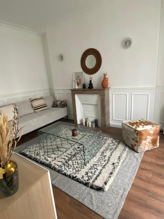 un salon avec un canapé et un tapis dans l'établissement Appartement à 10 min du Stade de France, à Saint-Denis