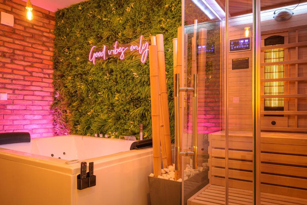 a bathroom with a bath tub and a green wall at Private Baltic Spa & Art Suite in Dziwnów