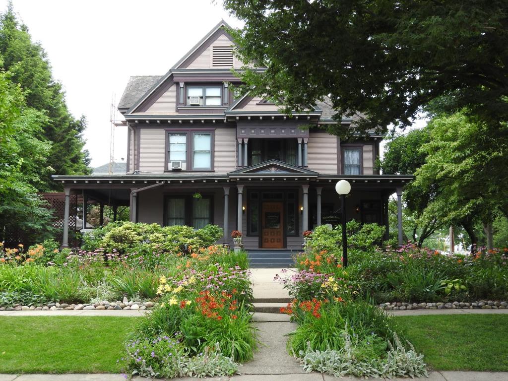 a house with a flower garden in front of it at Champaign Garden Inn in Champaign