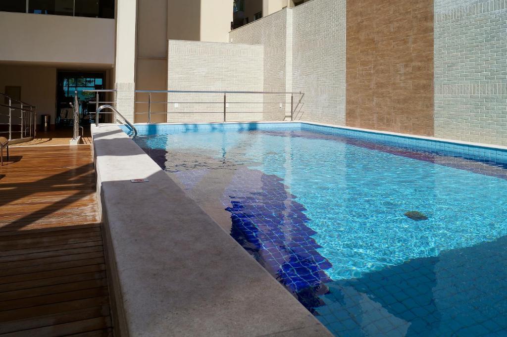 uma piscina com água azul num edifício em Alameda Vitória Hotel em Vitória