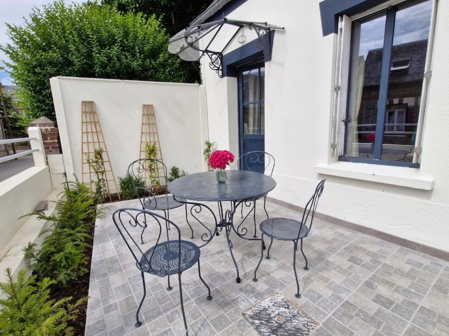 une table noire et des chaises sur une terrasse dans l'établissement Maison de pêcheurs entièrement rénovée, à Saint-Pierre-en-Port
